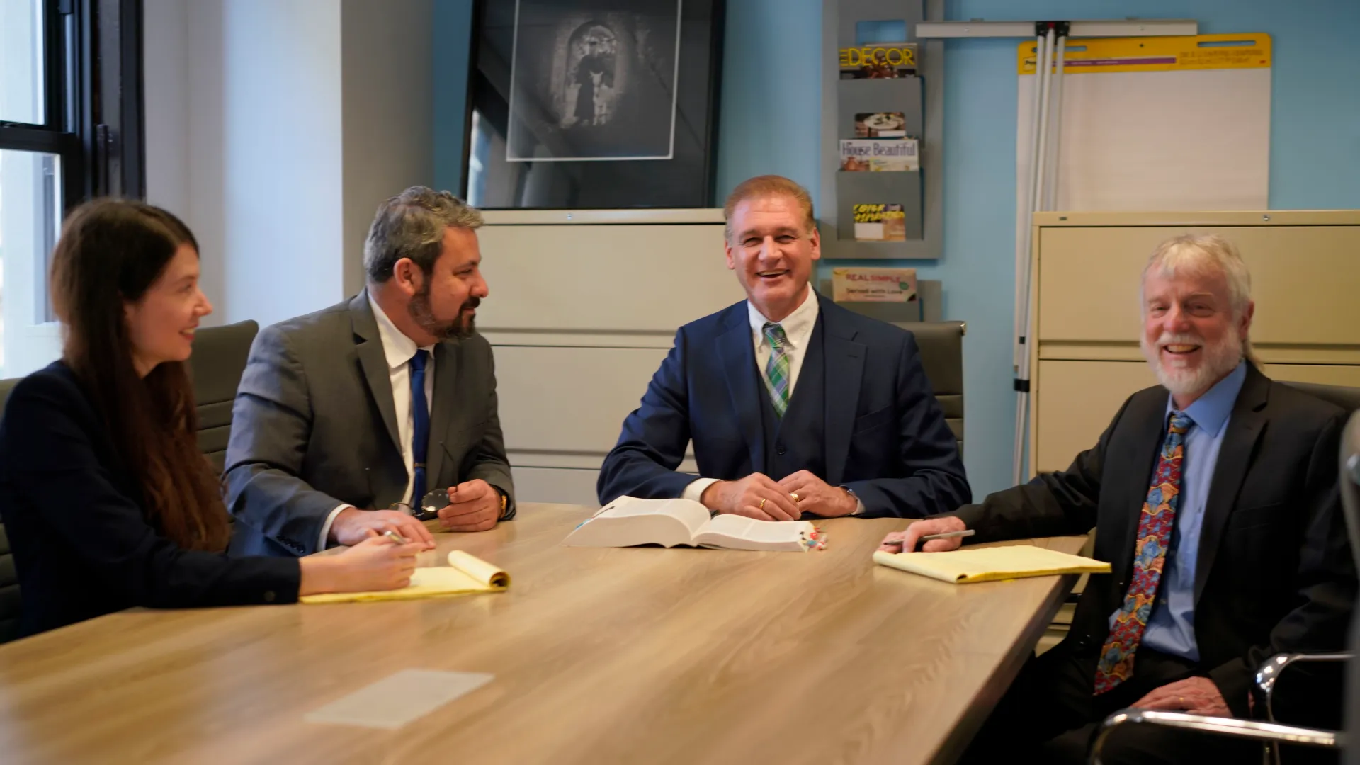 Four smiling lawyers at FitzGerald Law Company conference table.